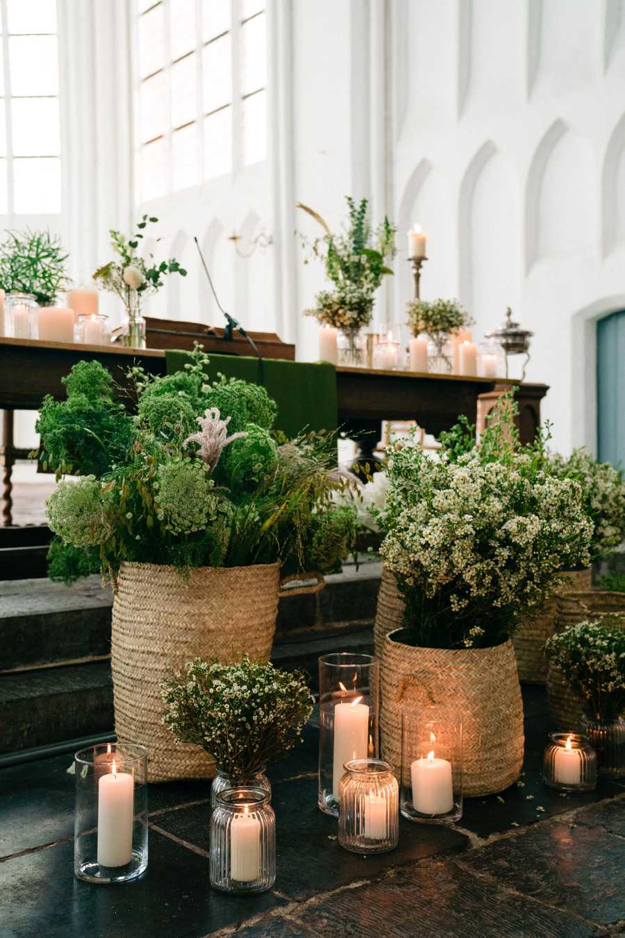 altar decorated with a lot of greens and candles
